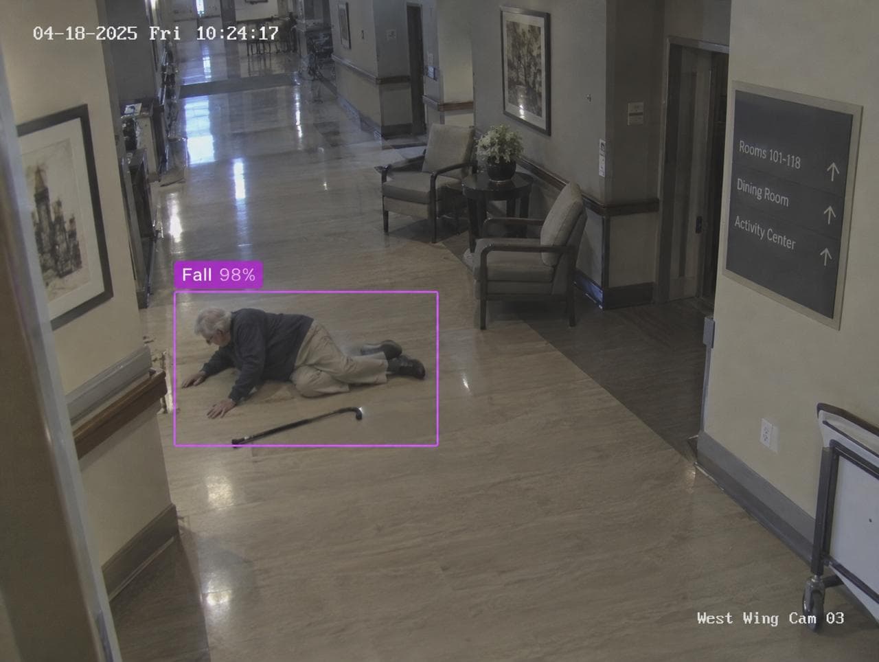 Hallway camera in a senior residence: a man on the floor beside his cane, boxed and labelled Fall 98%